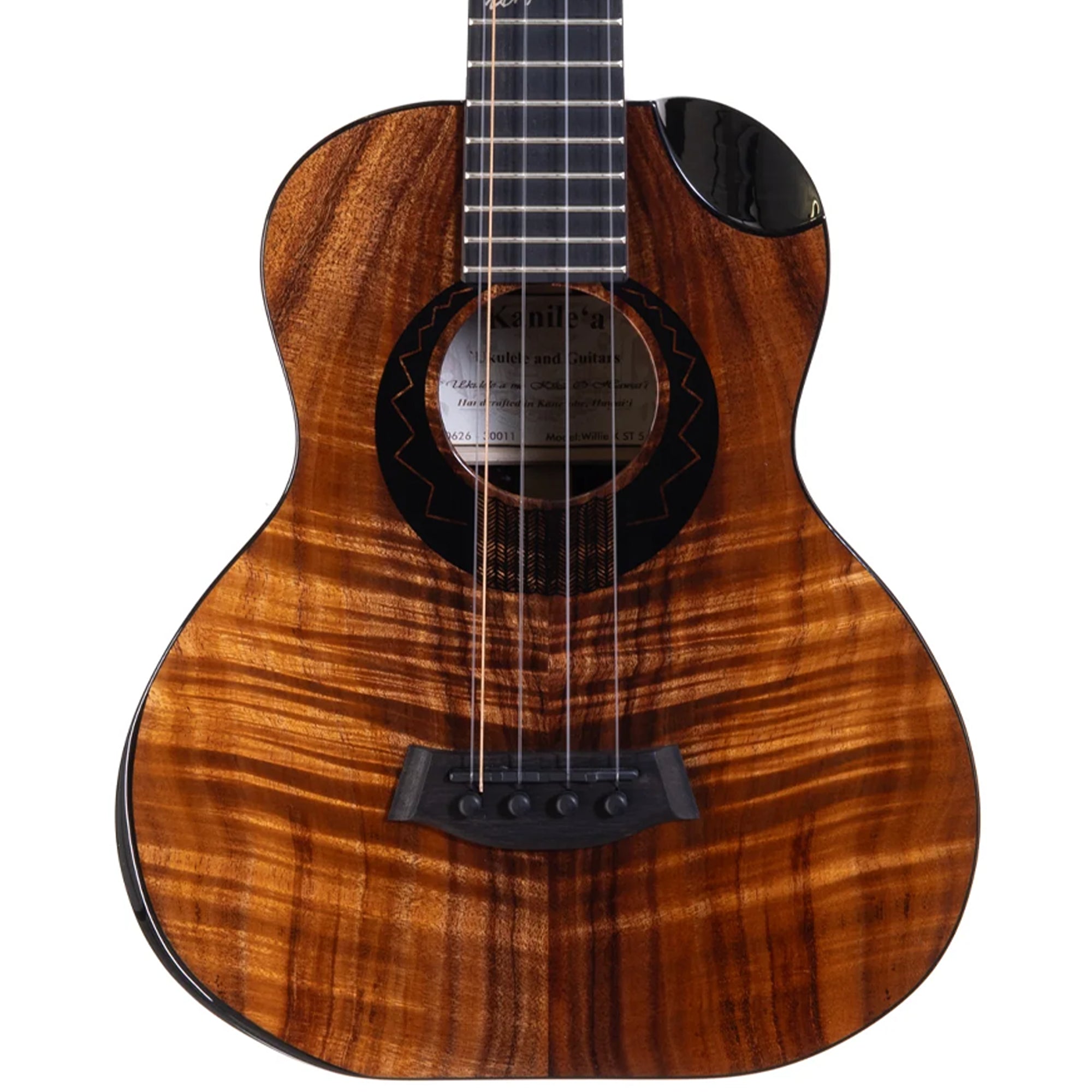 A close-up studio shot of a Kanile'a Willie`K 5-String Super Tenor Ukulele body with a rich, figured wood grain finish in warm brown and amber tones, featuring a black soundhole rosette, bridge, and tailpiece, and part of the dark fretboard visible at the top.