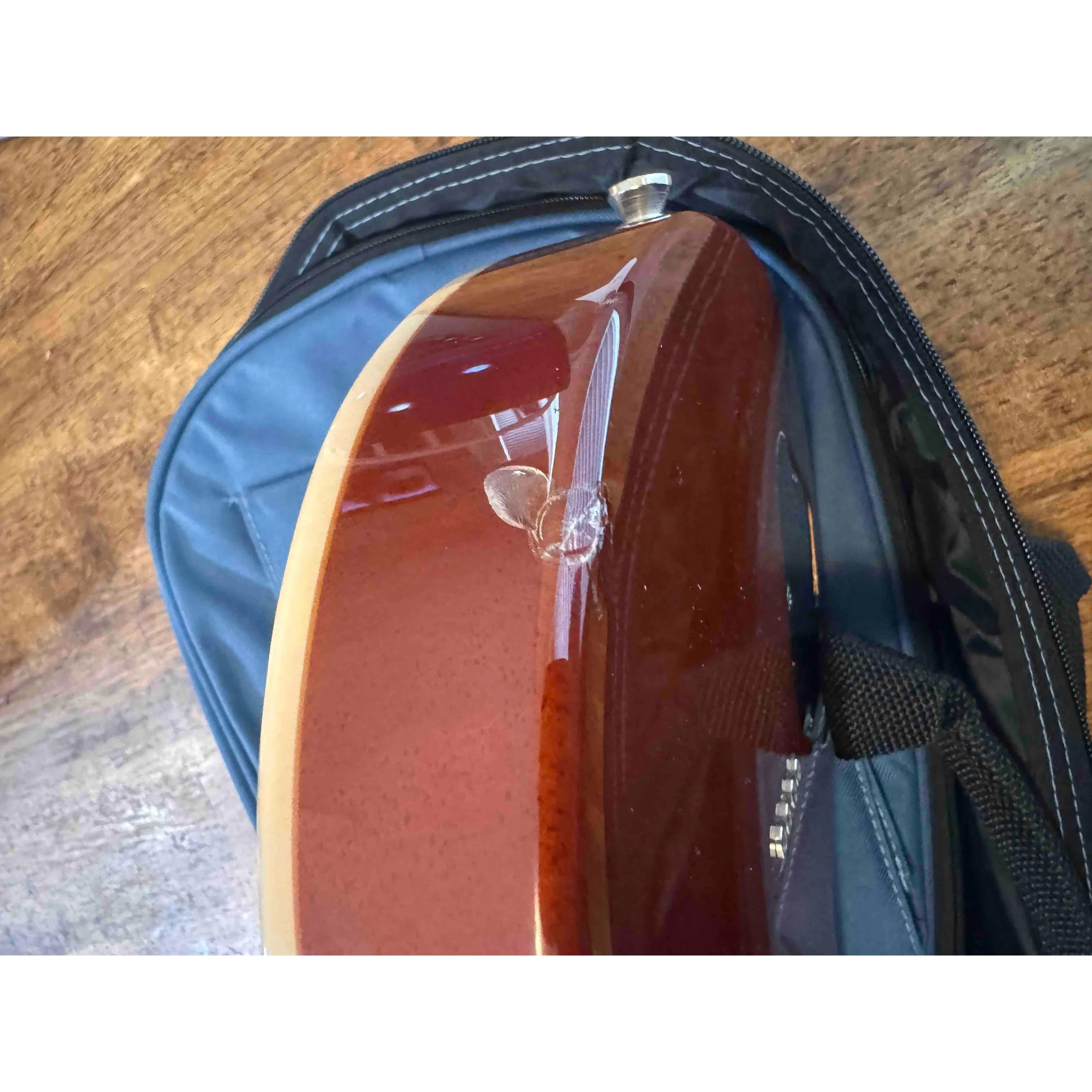 Close-up of the back of a Flight Centurion GT Vintage Gold electric tenor ukulele, showing a cosmetic blemish.