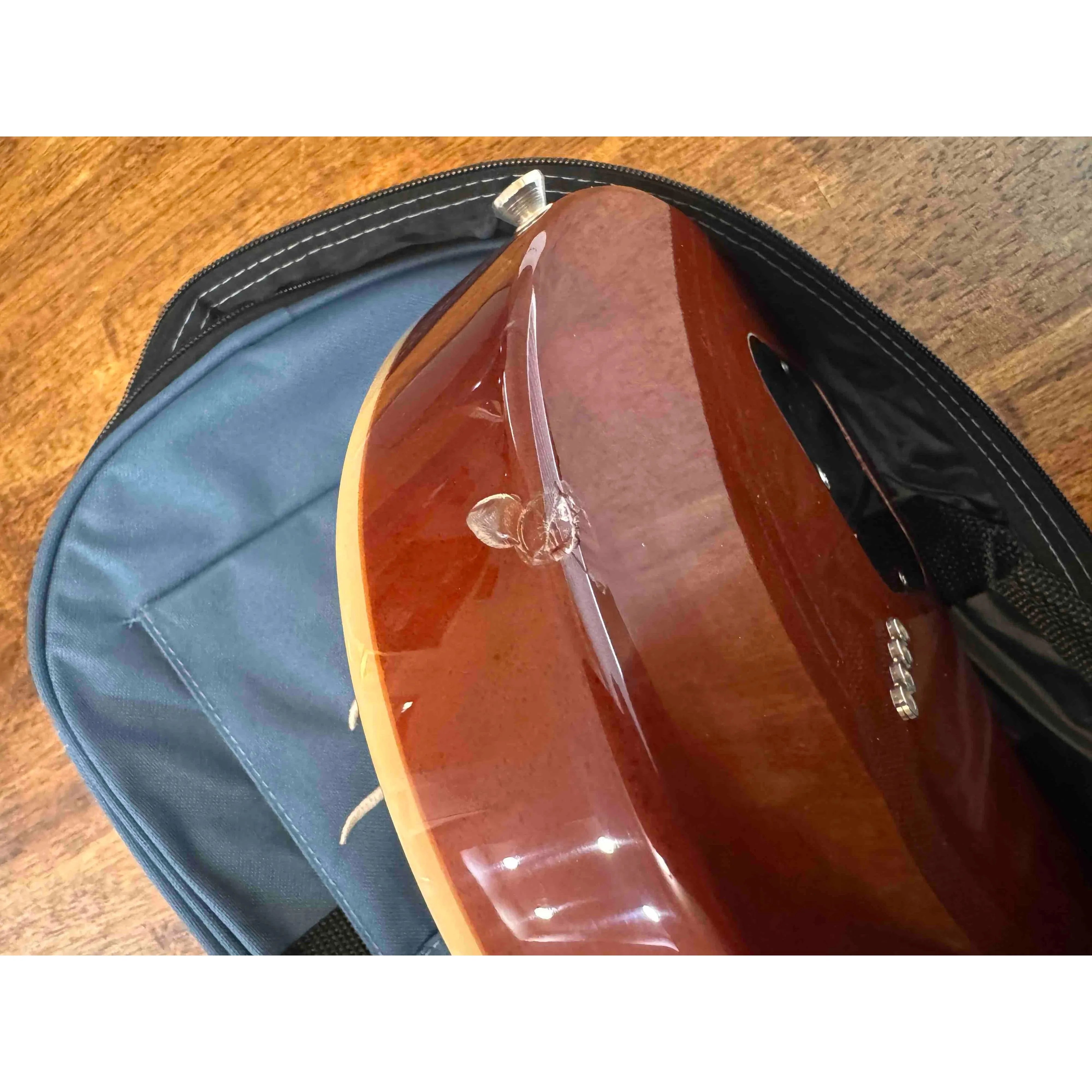 Close-up of the blemished back of a Flight Centurion GT Vintage Gold Electric Tenor Ukulele.