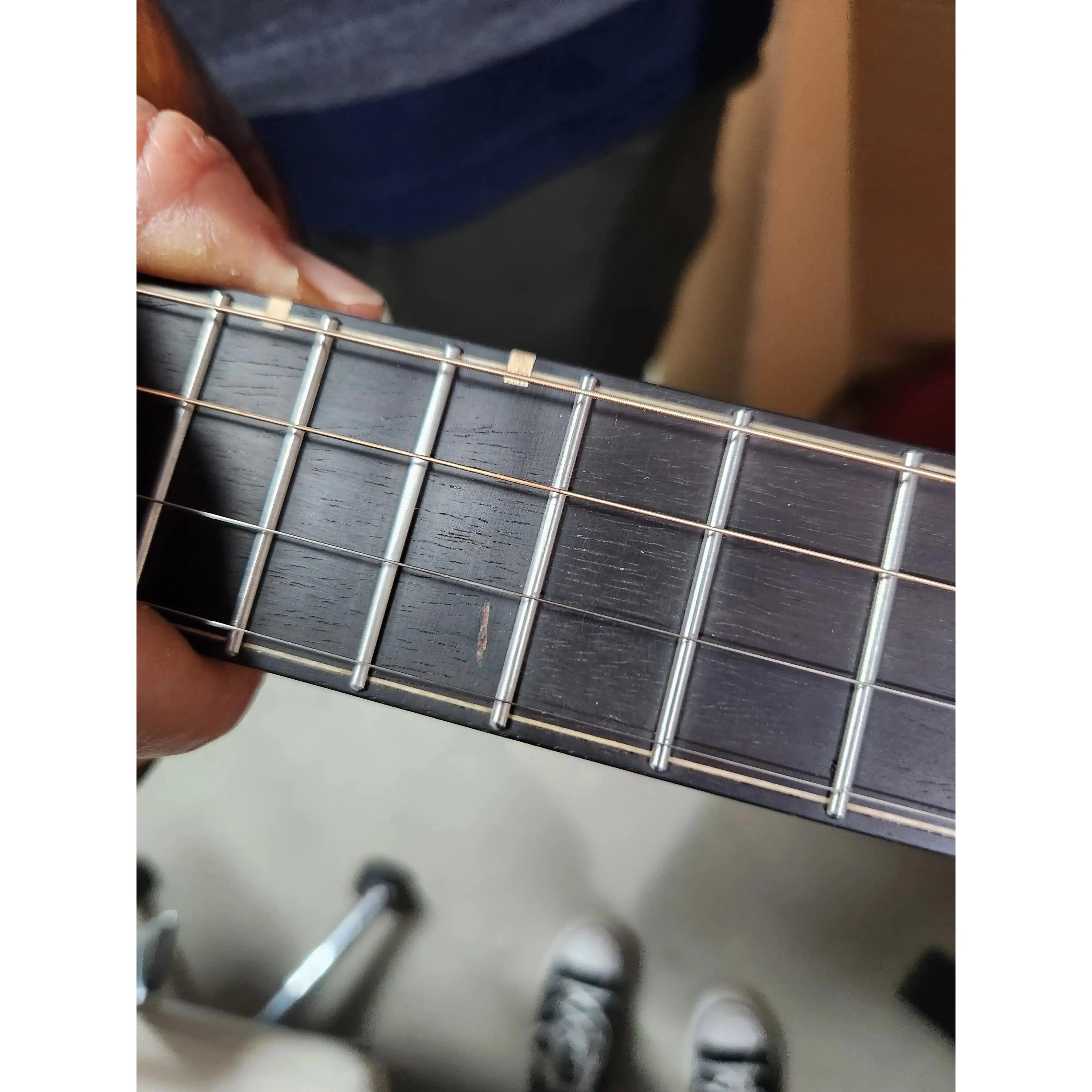 Close-up of Flight Lily EQ-A Baritone Ukulele rosewood fretboard showing a small nick on the 10th fret.