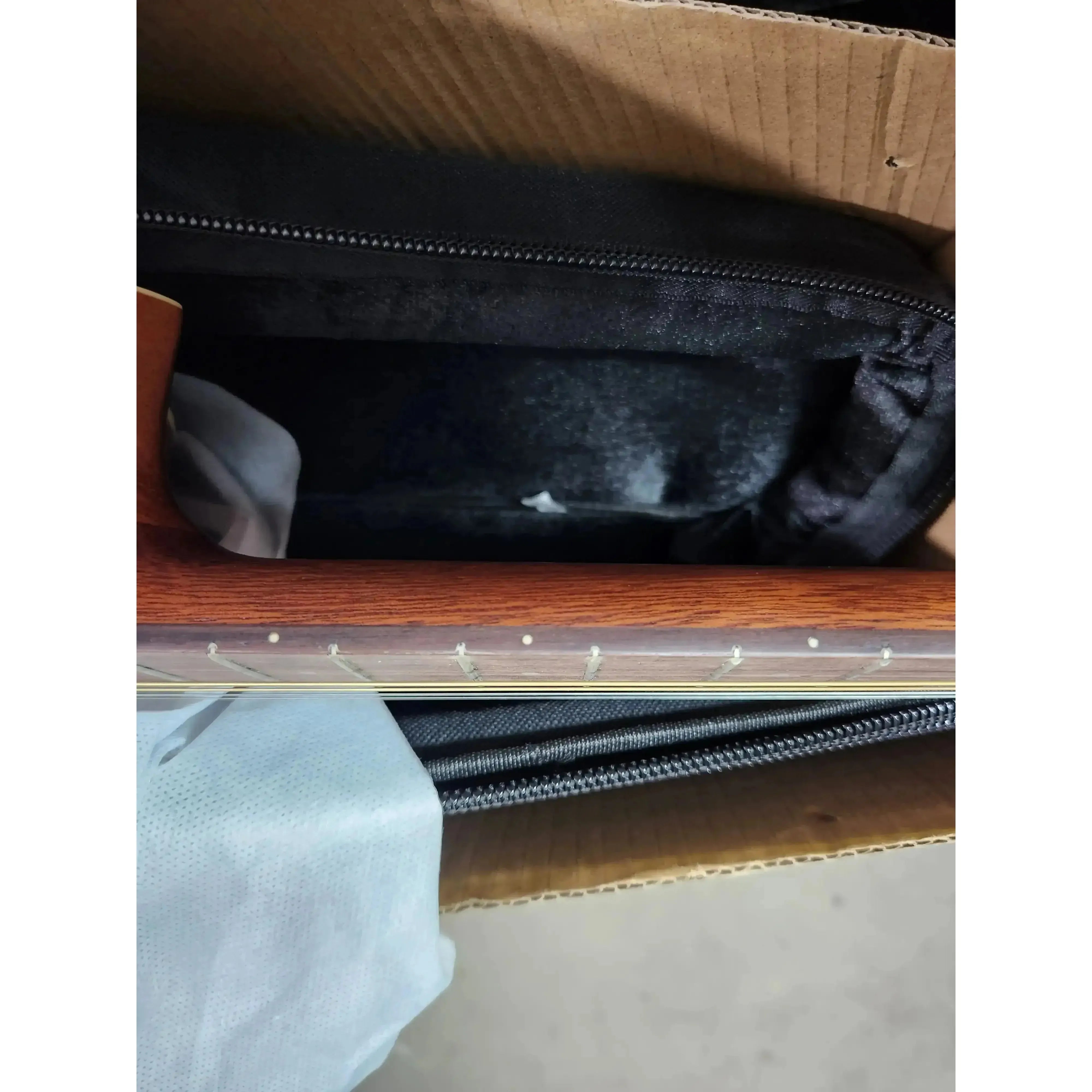 Kala GTR-TB tenor guitar fretboard with visible chipping, packed in a box.
