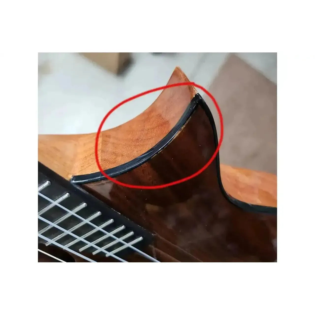 Kala Revelator Night Owl Acacia Tenor Ukulele cutaway with discoloration under the finish, circled in red.