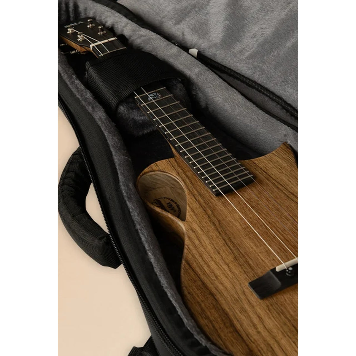 Kala Revelator tenor ukulele resting in the open Revelator Transit Series gig bag with plush gray interior and padded handle.
