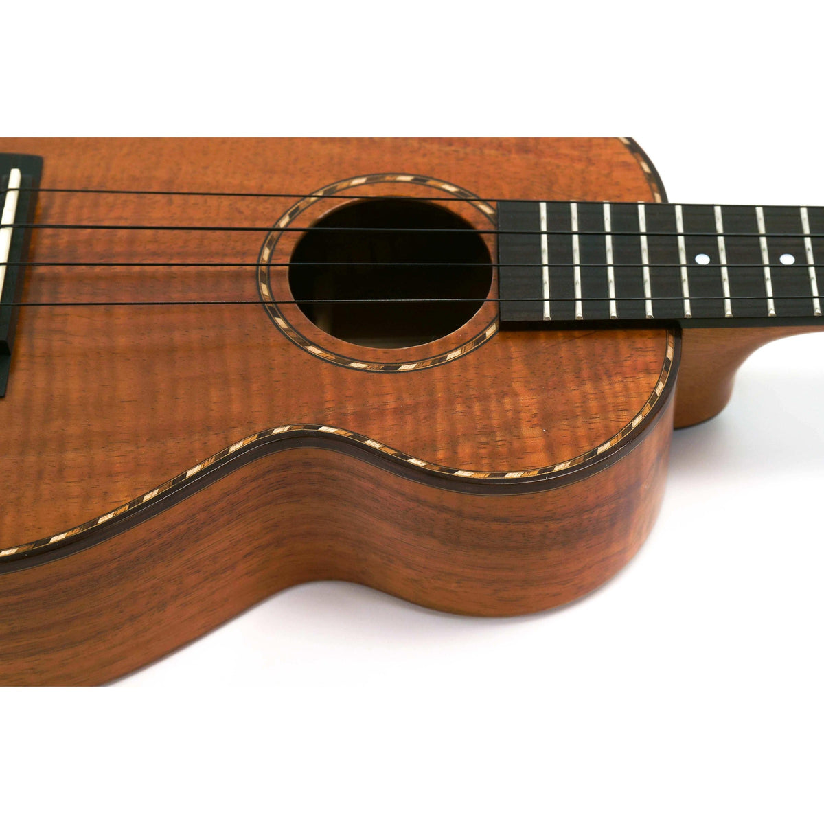 Kamaka HF-2Di concert ukulele close-up at an angle of the soundhole, rope rosette and ebony fretboard