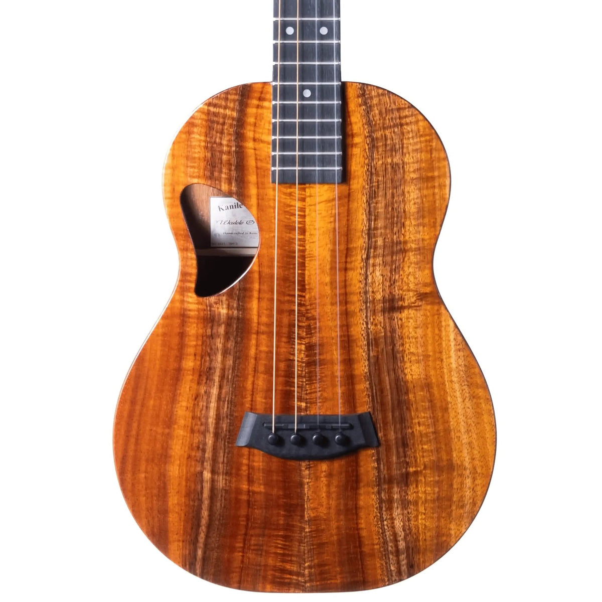 Example photo: an earlier Kanile'a D-1 Pro baritone, body front with figured Premium Grade koa, D-shaped soundhole and ebony bridge