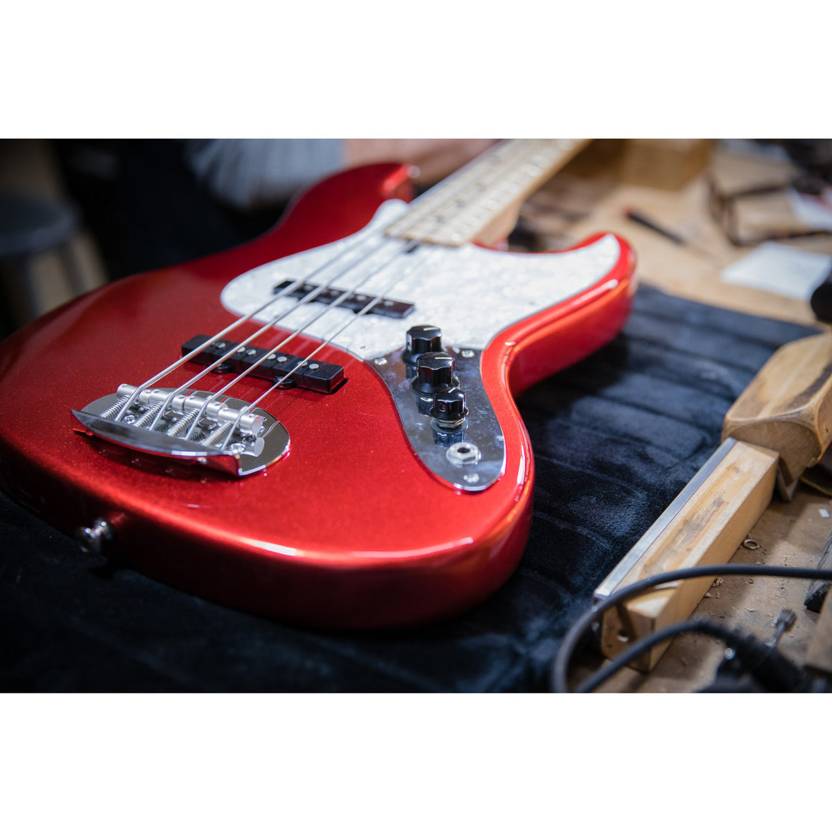 Lakland 44-60 in Candy Apple Red on the workbench, showing the red finish, pearl pickguard and J pickups