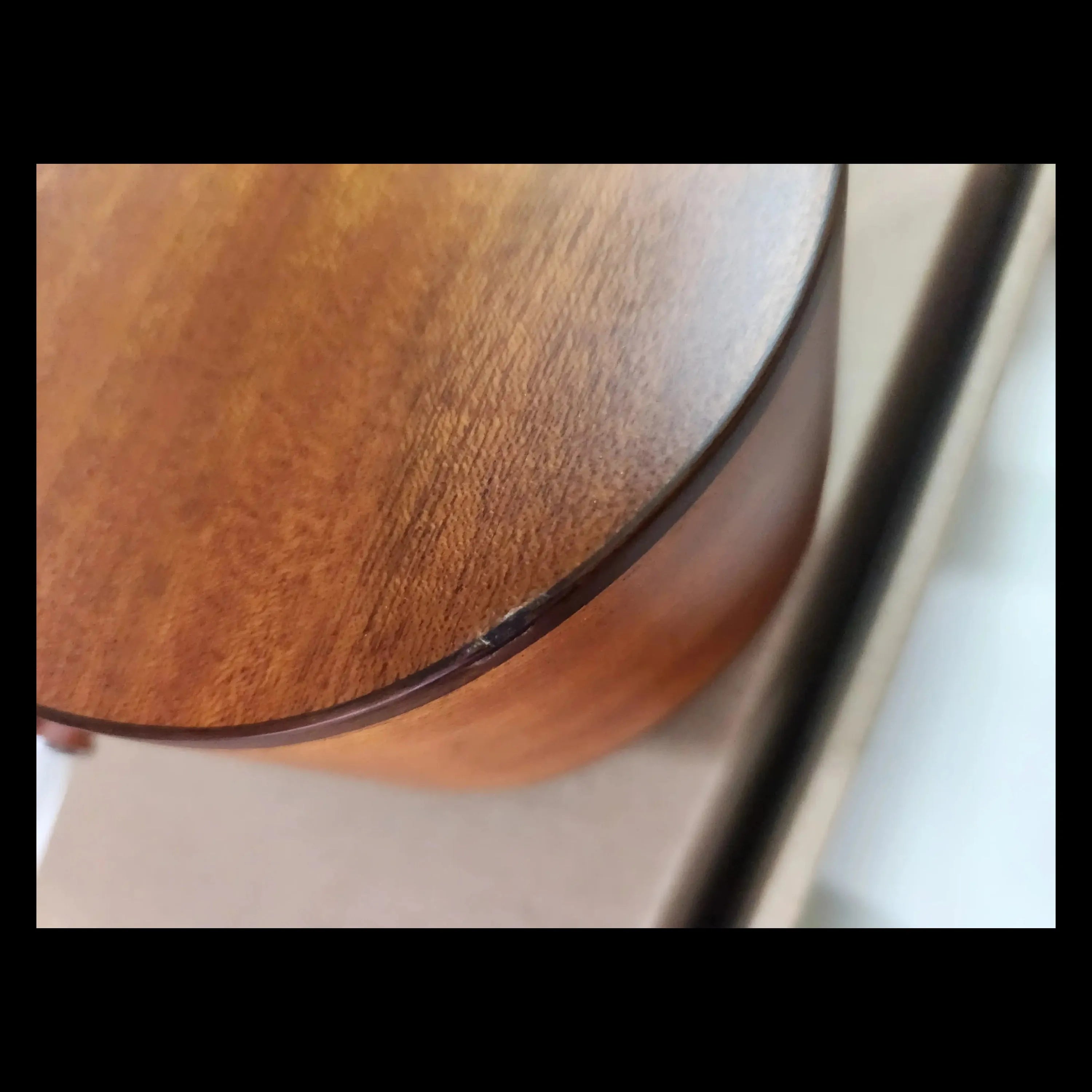 Detail of a nick on the back of a solid mahogany Ohana CK-35L Longneck Concert Ukulele body.