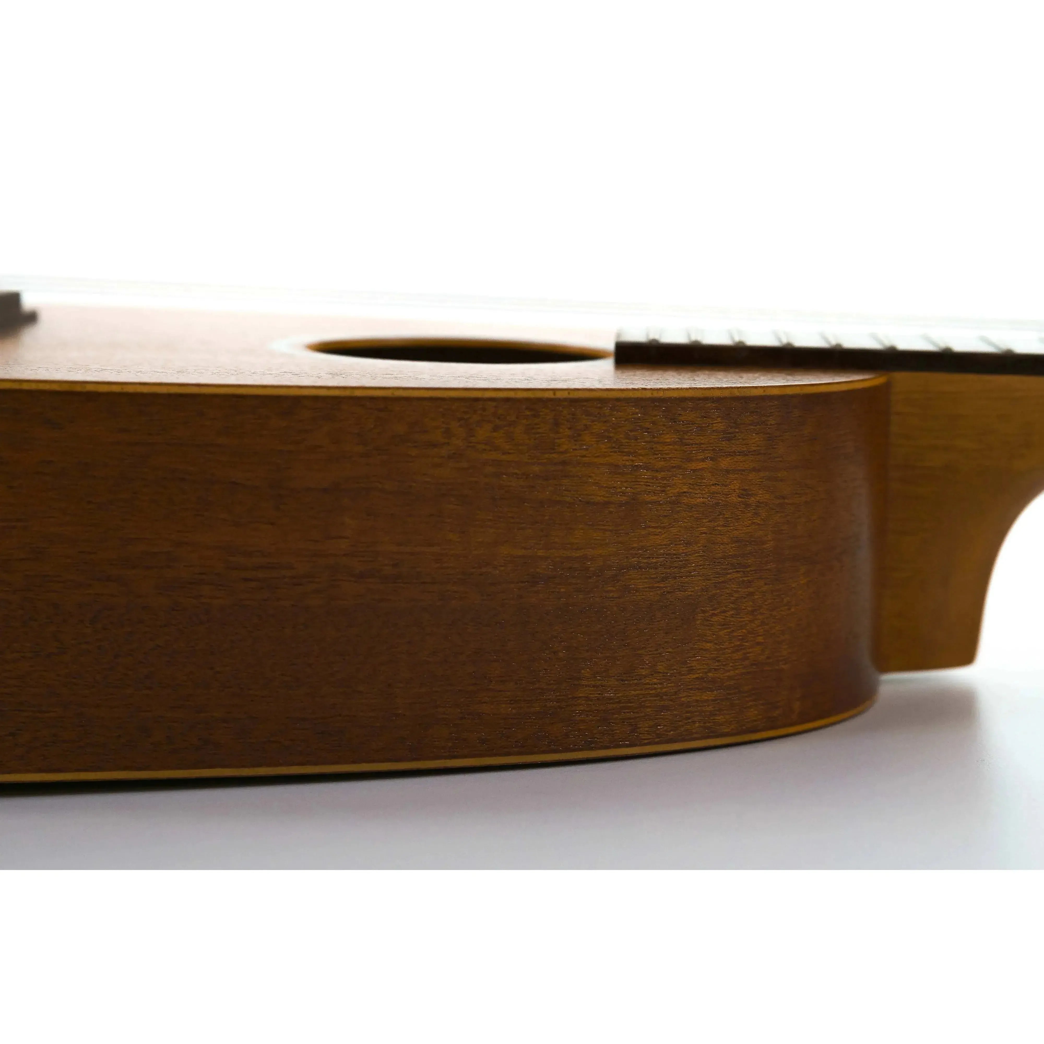 Side view of an Ohana PKC-10 Mahogany Pineapple Concert Ukulele with a satin finish.