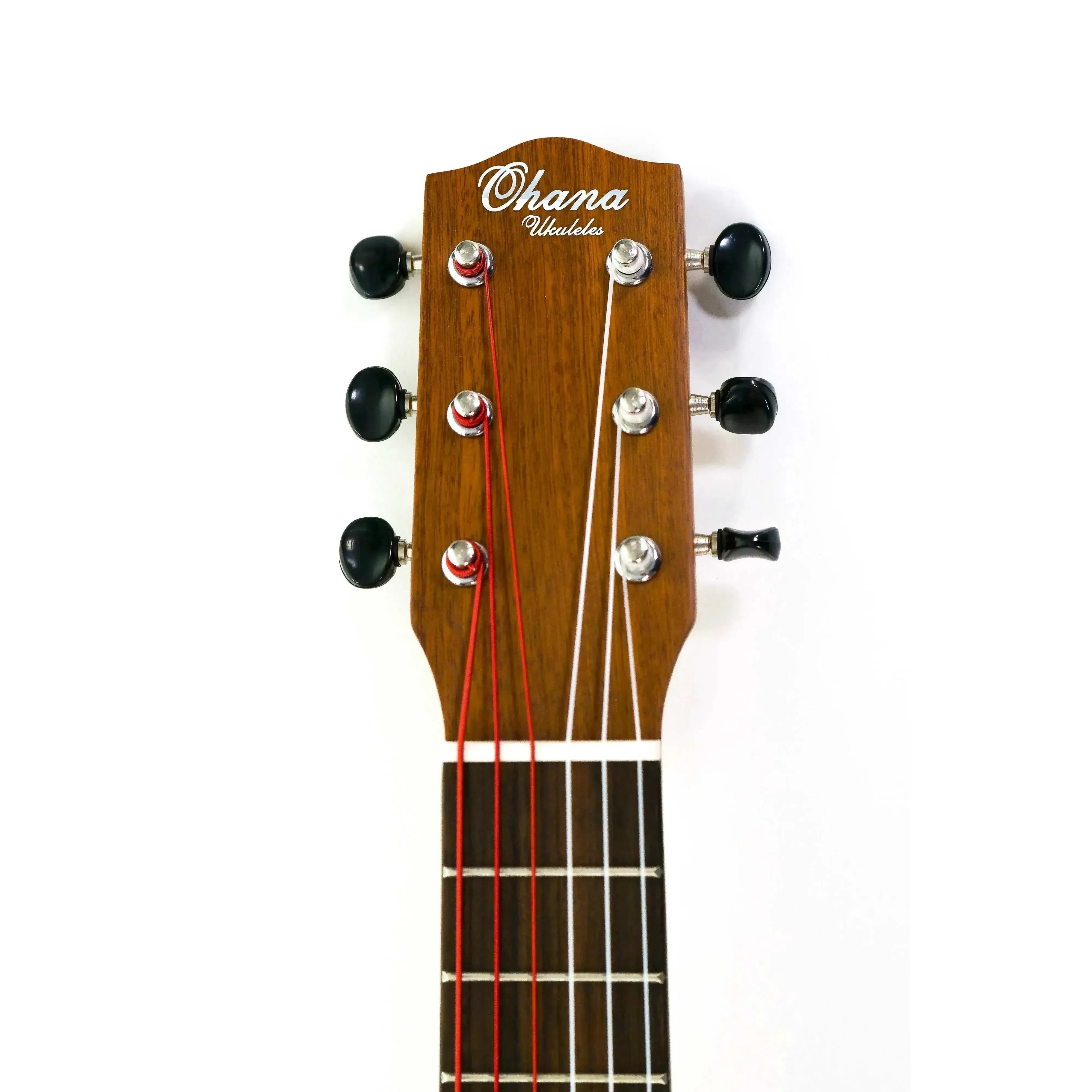 Ohana TKG-20 mini-guitar headstock with mahogany finish, black tuners, and red and white strings.