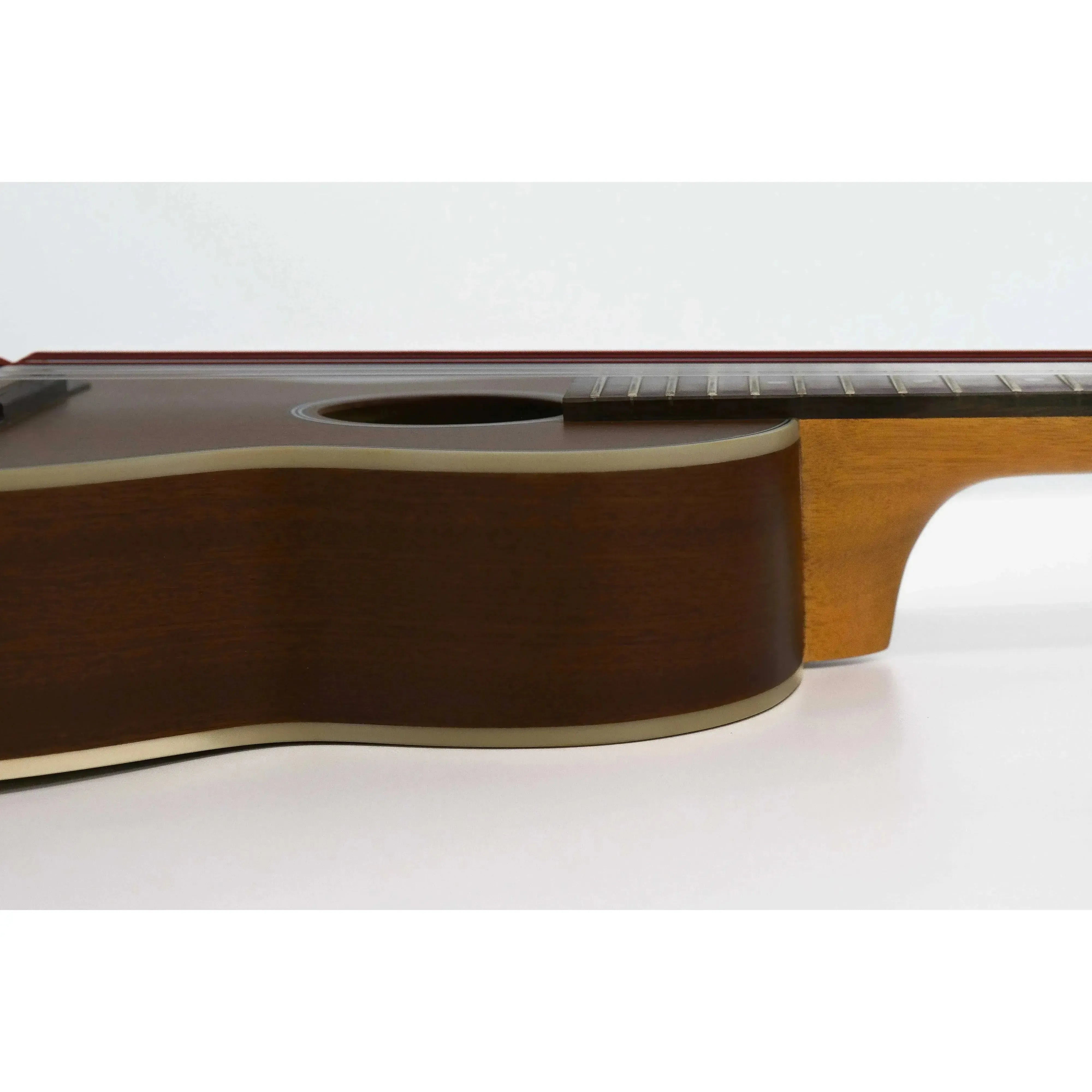 Ohana TKG-20E guitarlele body with mahogany top, cream binding, and soundhole.